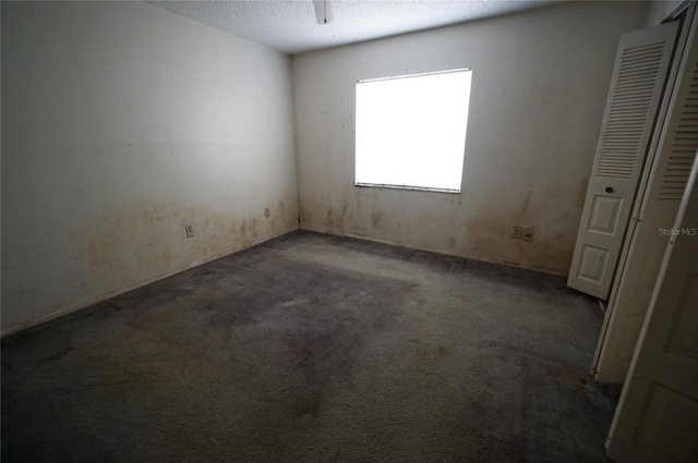 carpeted empty room with a textured ceiling