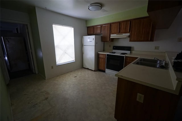 kitchen featuring range with electric stovetop, freestanding refrigerator, a sink, under cabinet range hood, and light countertops