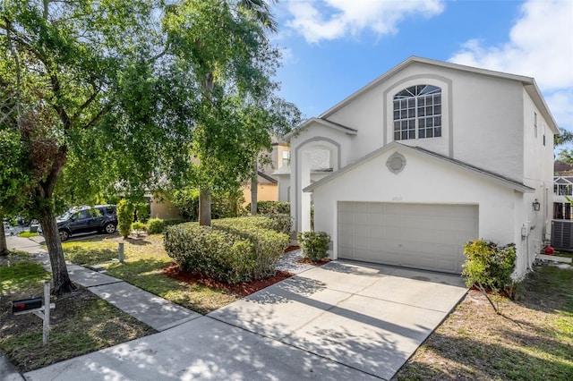 view of front of property with concrete driveway, central AC, a garage, and stucco siding