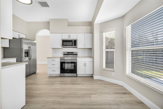 kitchen featuring visible vents, white cabinets, and stainless steel appliances