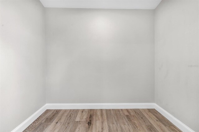 empty room with light wood-style floors and baseboards