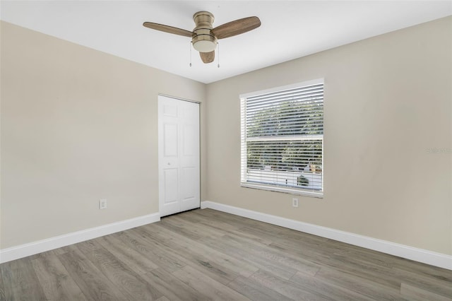 unfurnished room featuring a ceiling fan, baseboards, and wood finished floors