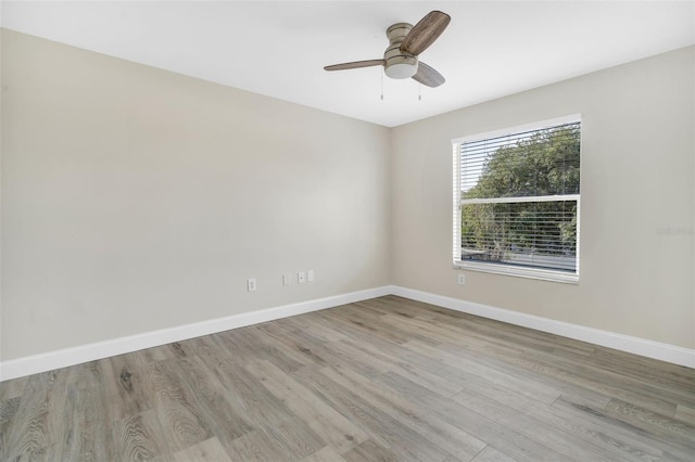 spare room with baseboards, ceiling fan, and wood finished floors