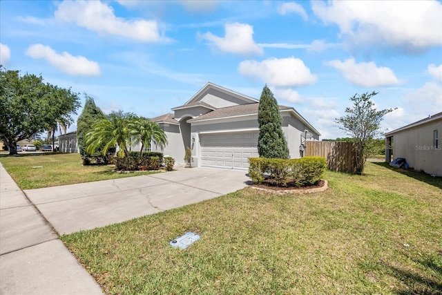 ranch-style home with an attached garage, stucco siding, fence, a front yard, and driveway