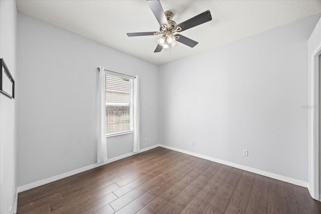 spare room featuring wood finished floors, baseboards, and ceiling fan