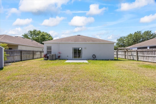 rear view of house with central air condition unit, a patio area, a yard, stucco siding, and a fenced backyard