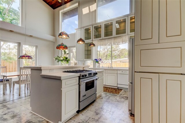 919 Sandpiper Way S, Saint Petersburg, FL 33707 - kitchen featuring stainless steel gas range, a healthy amount of sunlight, light countertops, and white dishwasher