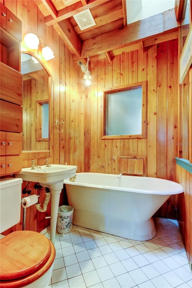 919 Sandpiper Way S, Saint Petersburg, FL 33707 - bathroom featuring a freestanding bath, wooden walls, visible vents, and tile patterned flooring