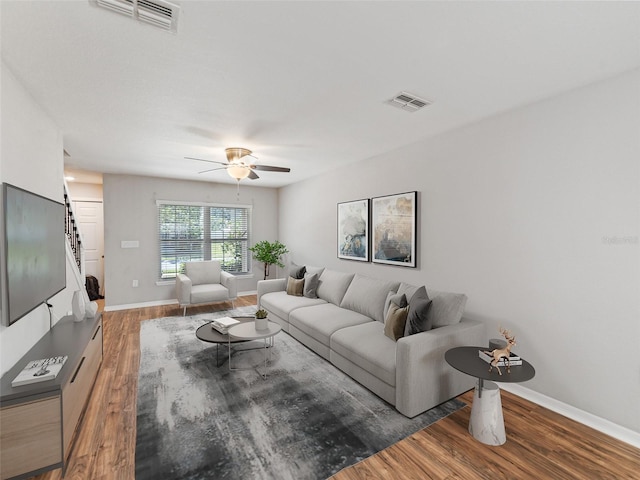 living area featuring visible vents, baseboards, ceiling fan, and wood finished floors