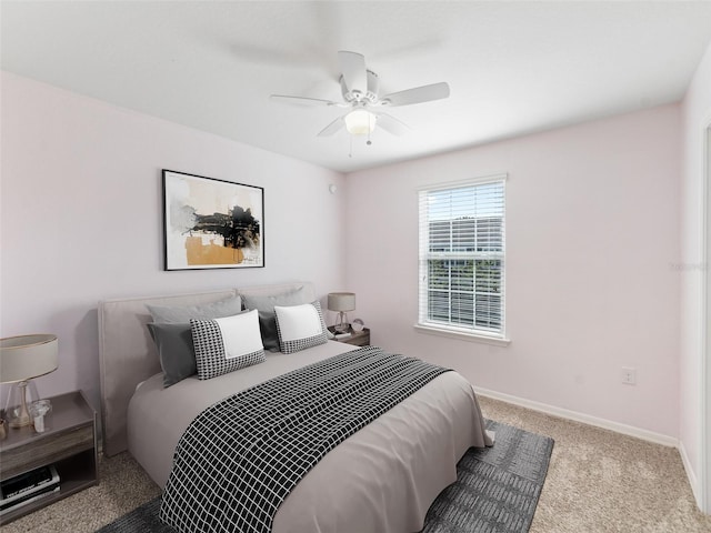carpeted bedroom featuring baseboards and a ceiling fan