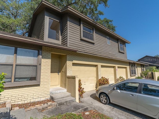 view of front of home with entry steps, a garage, and brick siding