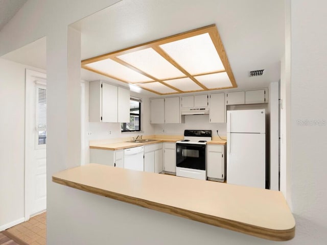 kitchen with a sink, white appliances, visible vents, under cabinet range hood, and light countertops