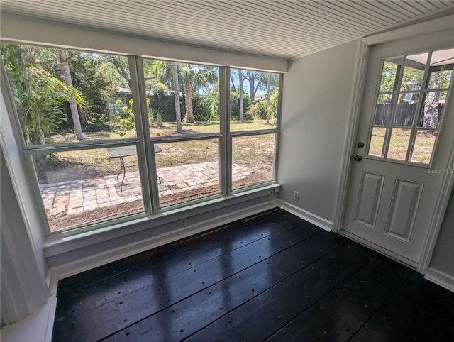 doorway with dark wood-style floors and baseboards