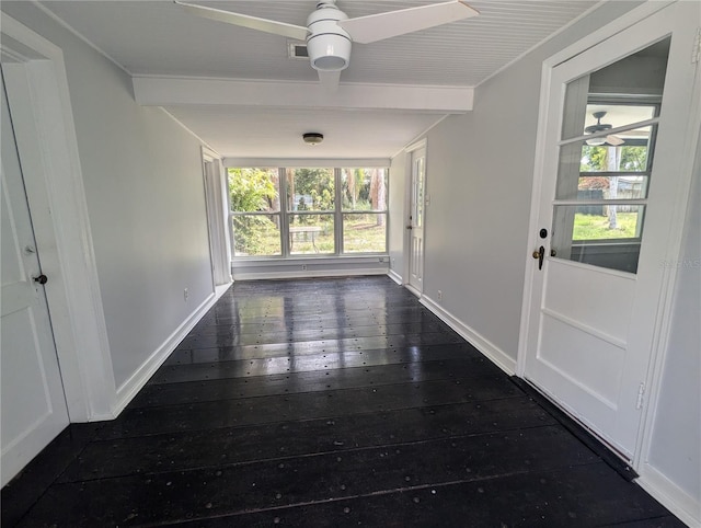 corridor with dark wood-type flooring, healthy amount of natural light, beam ceiling, and baseboards