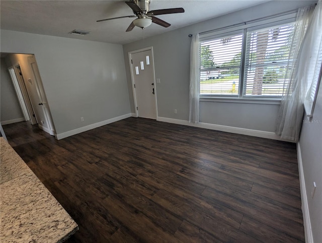 unfurnished living room with ceiling fan, dark wood-style floors, and baseboards