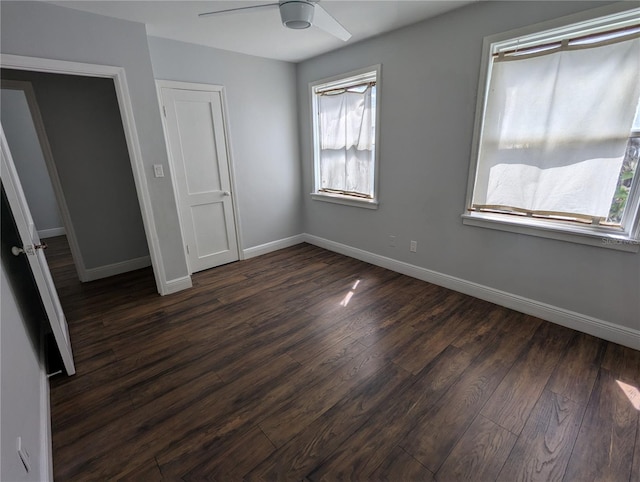 unfurnished bedroom with dark wood-type flooring, baseboards, and a ceiling fan
