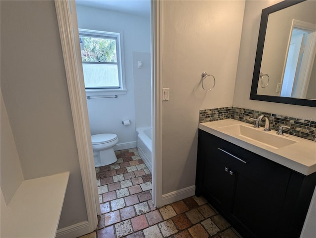 full bathroom with baseboards, toilet, vanity, a tub to relax in, and decorative backsplash