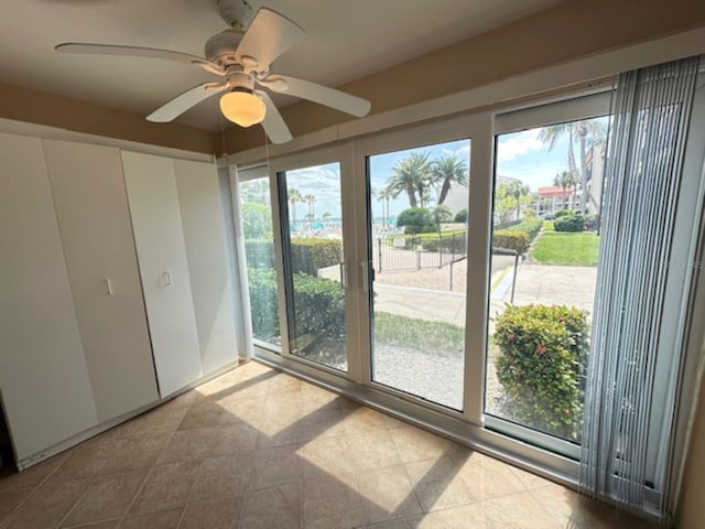 unfurnished bedroom featuring access to exterior, tile patterned flooring, and ceiling fan