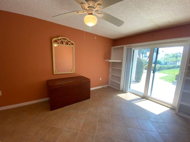unfurnished room featuring a textured ceiling, ceiling fan, baseboards, and tile patterned floors
