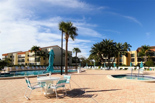 community pool with a hot tub and a patio area