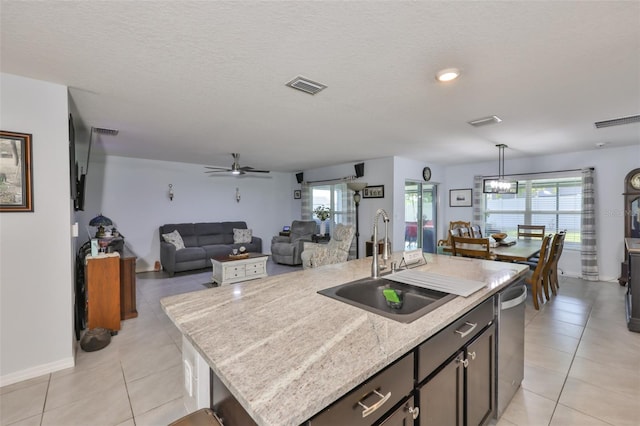 kitchen featuring a sink, visible vents, light countertops, light tile patterned floors, and stainless steel dishwasher
