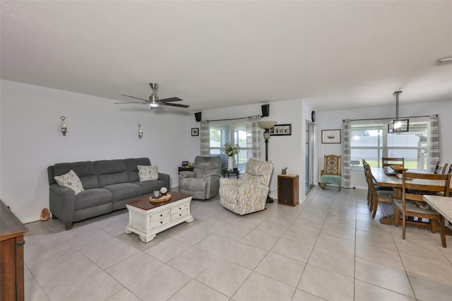 living area with a ceiling fan, light tile patterned floors, and a healthy amount of sunlight