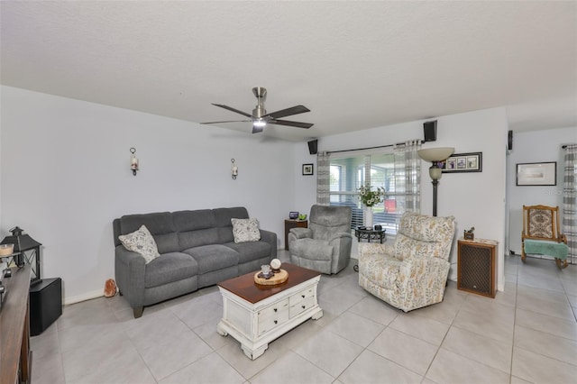 living area featuring a textured ceiling, light tile patterned flooring, and ceiling fan