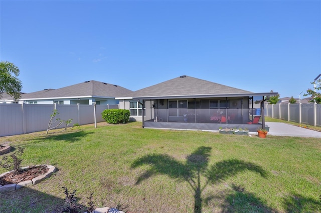 rear view of house with a fenced backyard, a sunroom, and a lawn