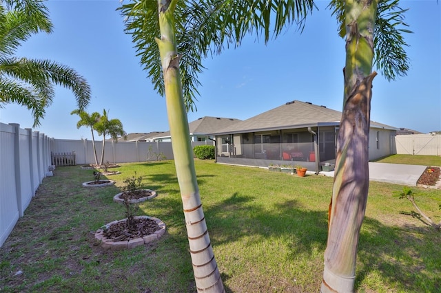 view of yard with a fenced backyard and a sunroom