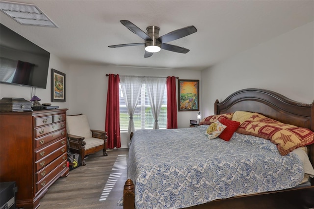 bedroom with a ceiling fan, visible vents, and dark wood finished floors
