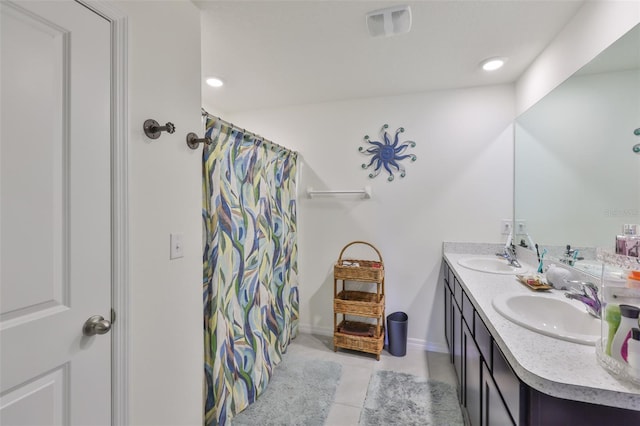 bathroom with tile patterned floors, double vanity, a sink, and visible vents