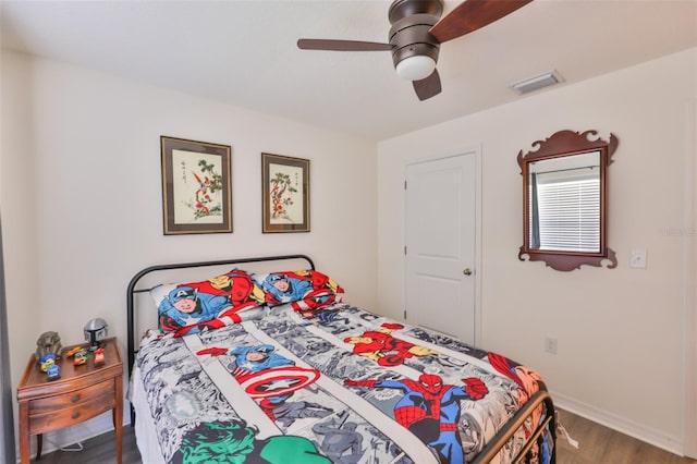 bedroom with visible vents, wood finished floors, and a ceiling fan