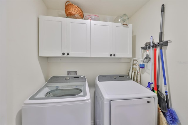 laundry area with independent washer and dryer and cabinet space
