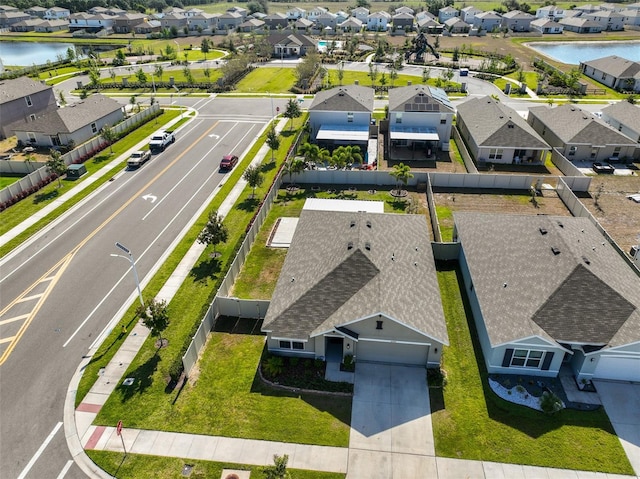 drone / aerial view featuring a water view and a residential view