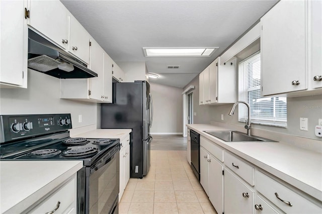 kitchen featuring black appliances, under cabinet range hood, a sink, and light countertops