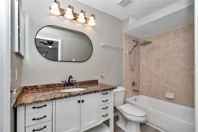 bathroom featuring a ceiling fan, vanity, toilet, and bathtub / shower combination