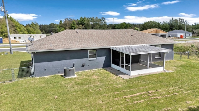 rear view of house with a shingled roof, a sunroom, central air condition unit, and a gate