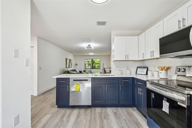 2953 Yucca Ct, Palm Harbor, FL 34684 - kitchen featuring stainless steel appliances, a sink, blue cabinetry, and white cabinets