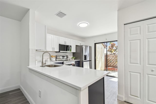 2953 Yucca Ct, Palm Harbor, FL 34684 - kitchen featuring stainless steel appliances, a sink, light countertops, wood finished floors, and white cabinets