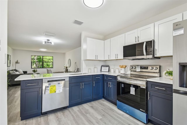 2953 Yucca Ct, Palm Harbor, FL 34684 - kitchen with appliances with stainless steel finishes, a sink, a peninsula, light countertops, and white cabinets