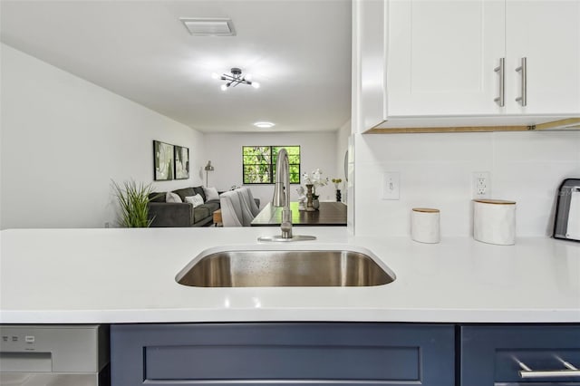 2953 Yucca Ct, Palm Harbor, FL 34684 - kitchen with a sink, light countertops, open floor plan, backsplash, and white cabinetry