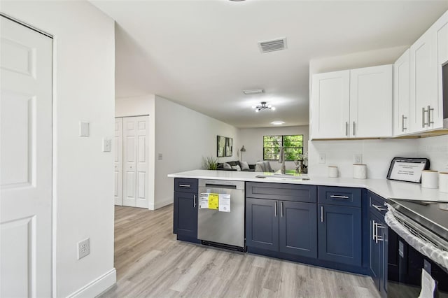 2953 Yucca Ct, Palm Harbor, FL 34684 - kitchen with appliances with stainless steel finishes, a sink, white cabinetry, light wood-type flooring, and blue cabinets