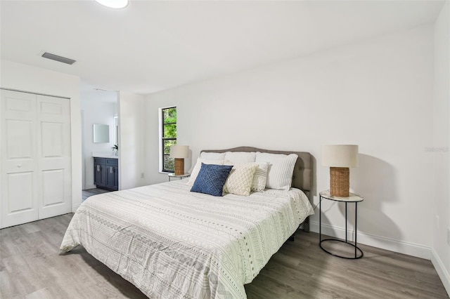 2953 Yucca Ct, Palm Harbor, FL 34684 - bedroom featuring wood finished floors, a closet, baseboards, and ensuite bathroom