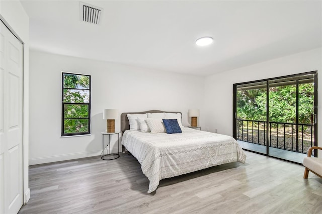 2953 Yucca Ct, Palm Harbor, FL 34684 - bedroom with access to exterior, multiple windows, wood finished floors, and baseboards