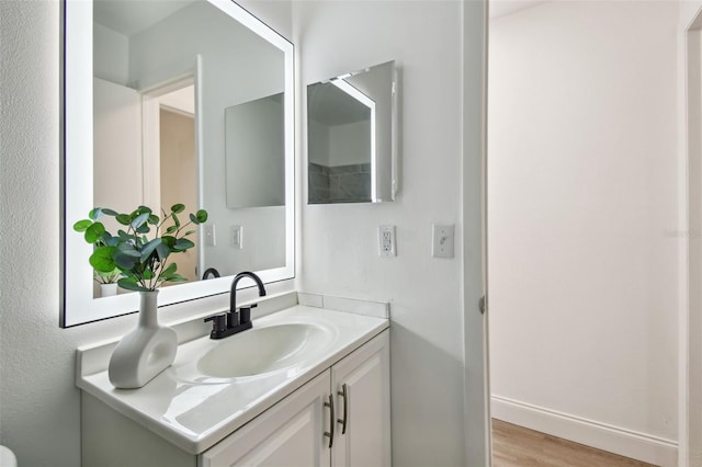 2953 Yucca Ct, Palm Harbor, FL 34684 - bathroom featuring vanity, wood finished floors, and baseboards