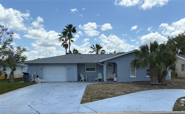 ranch-style home featuring a garage, stucco siding, and driveway