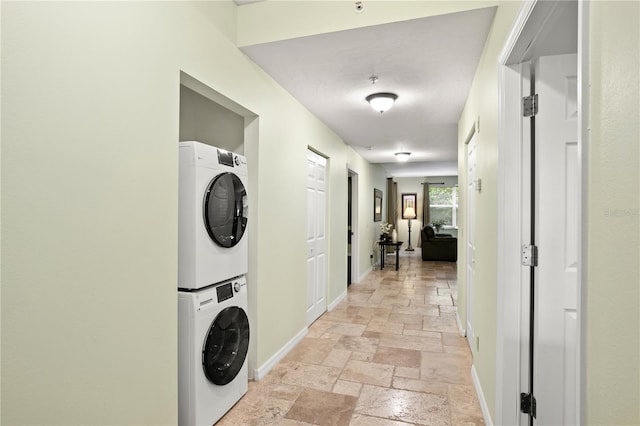 3506 54th Dr W Unit 108, Bradenton, FL 34210 - laundry room with laundry area, stacked washer and dryer, baseboards, and stone tile floors