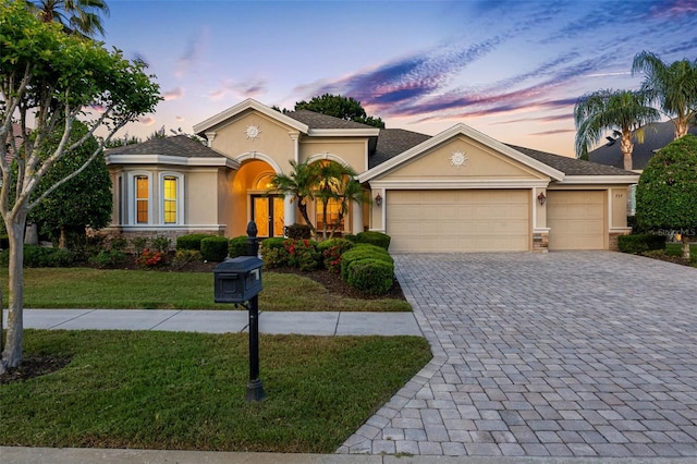 view of front facade with stone siding, a garage, stucco siding, decorative driveway, and a front yard