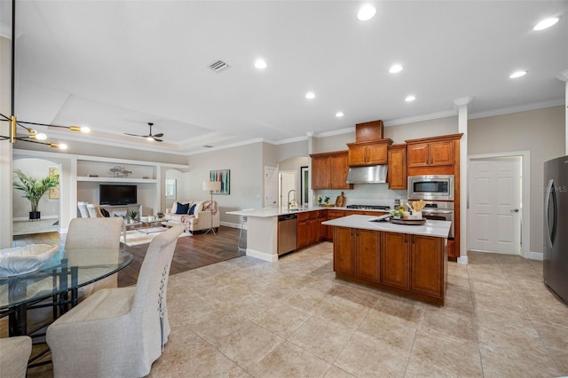 kitchen featuring ornamental molding, open floor plan, appliances with stainless steel finishes, and under cabinet range hood