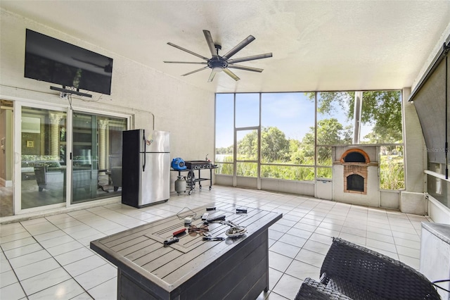 living area featuring light tile patterned floors, ceiling fan, and a fireplace